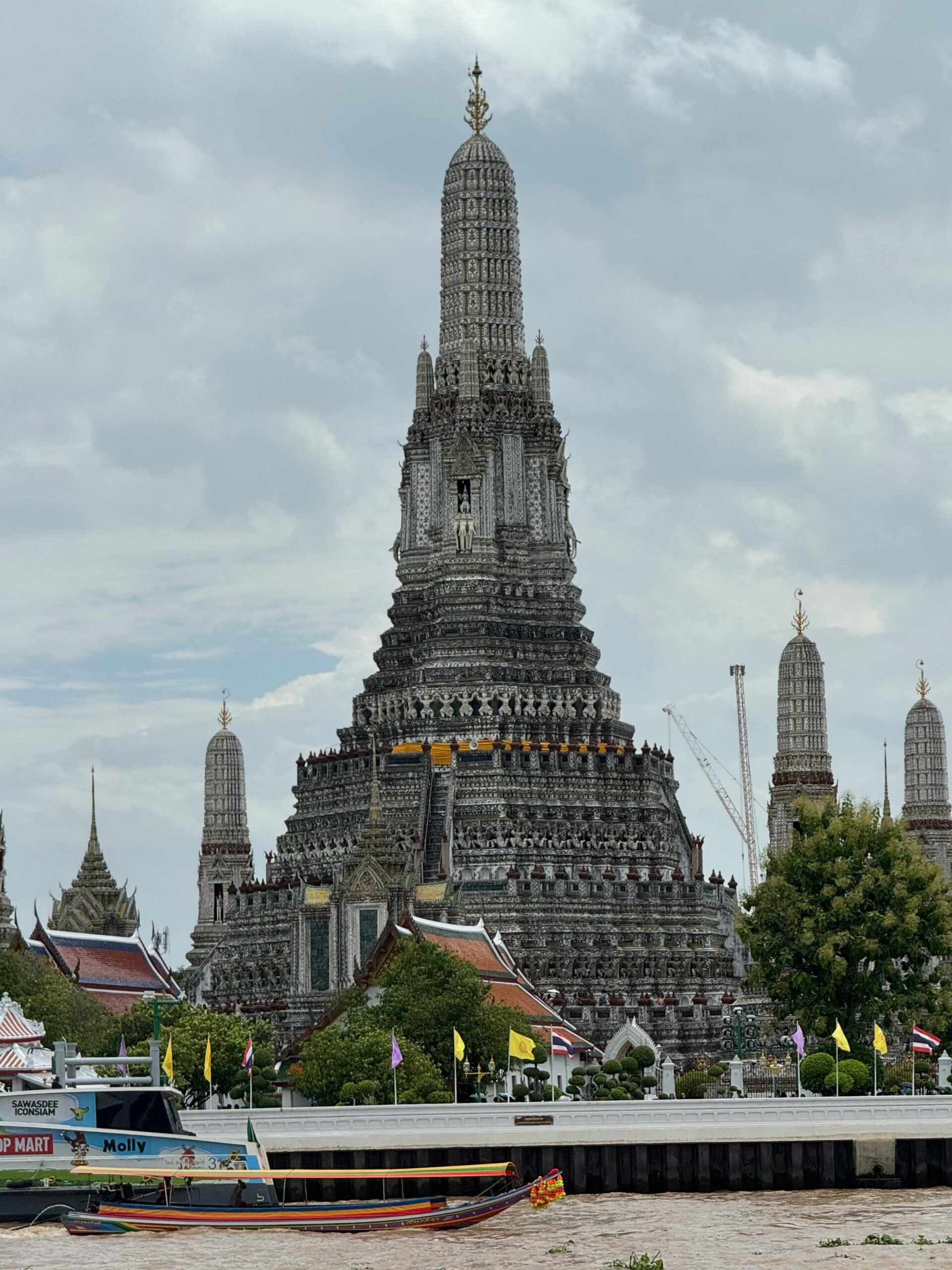 A captivating view of Wat Arun by the Chao Phraya River, showcasing Thailand's architectural beauty.