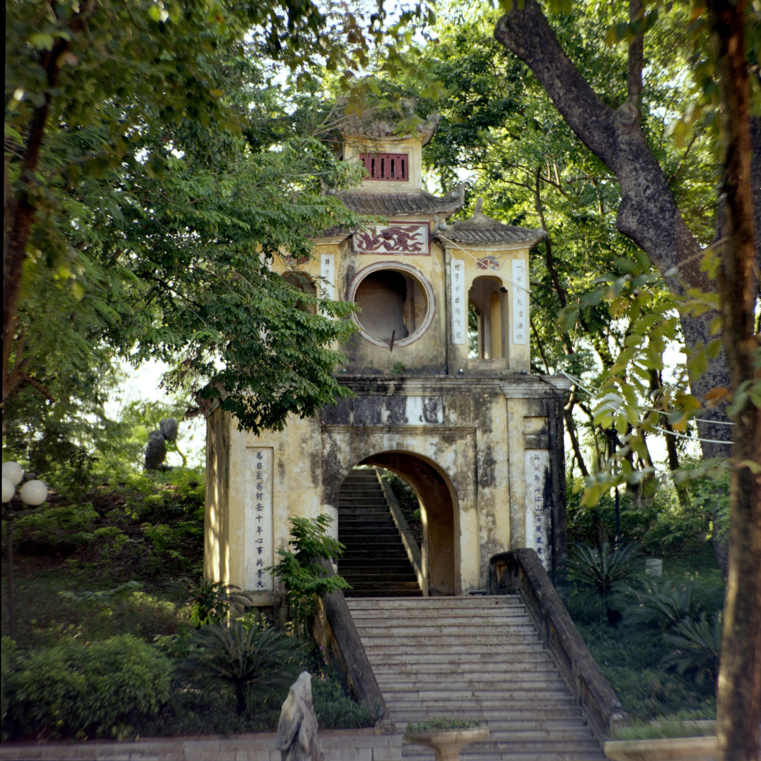 A historic pagoda amidst lush greenery in Hanoi, exemplifying Vietnamese architecture.